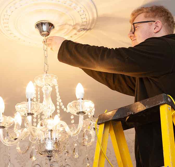 domestic electrician checking a light